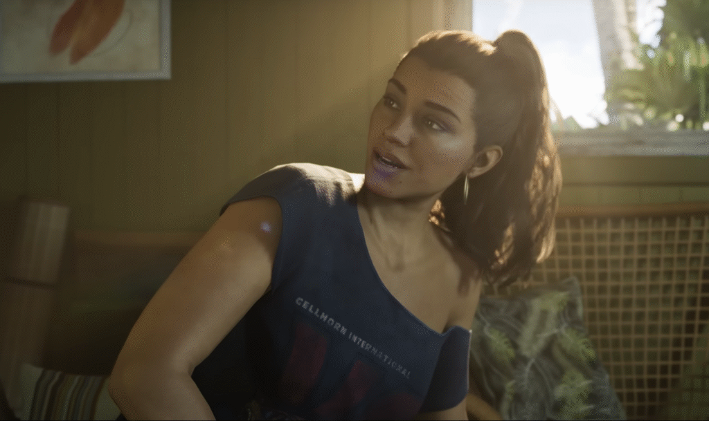 Lucia sitting indoors in GTA 6 Trailer 2, speaking with relaxed expression and sunlight behind her